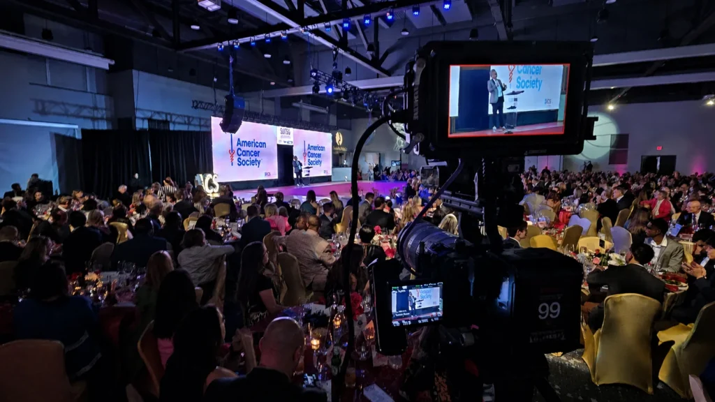 Live multicamera production at the American Cancer Society Suits and Sneakers Gala with the stage framed through a production monitor